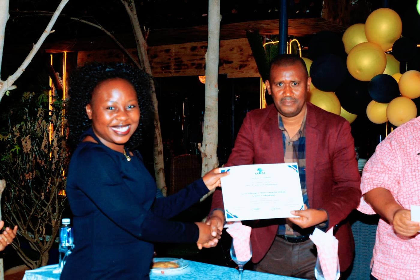 A participant receiving her certificate at the URU gene editing short course